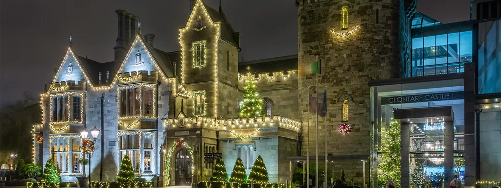 Clontarf Castle at night, outlined in warm Christmas lights