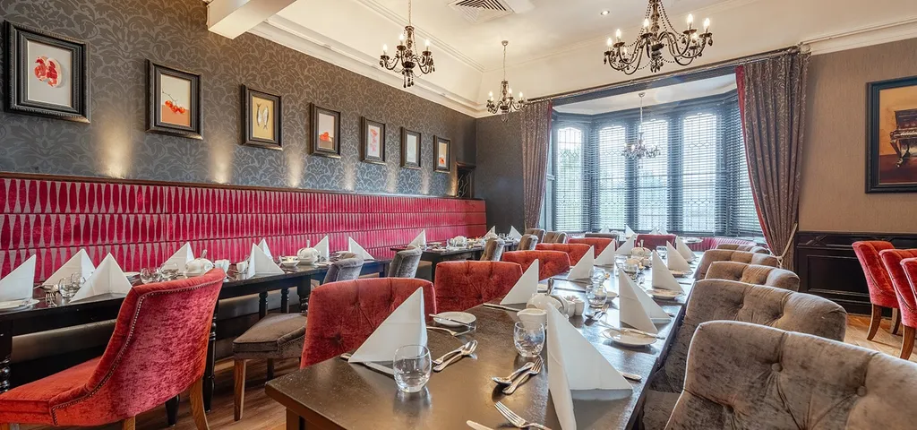 Dining room with red banquettes and set tables