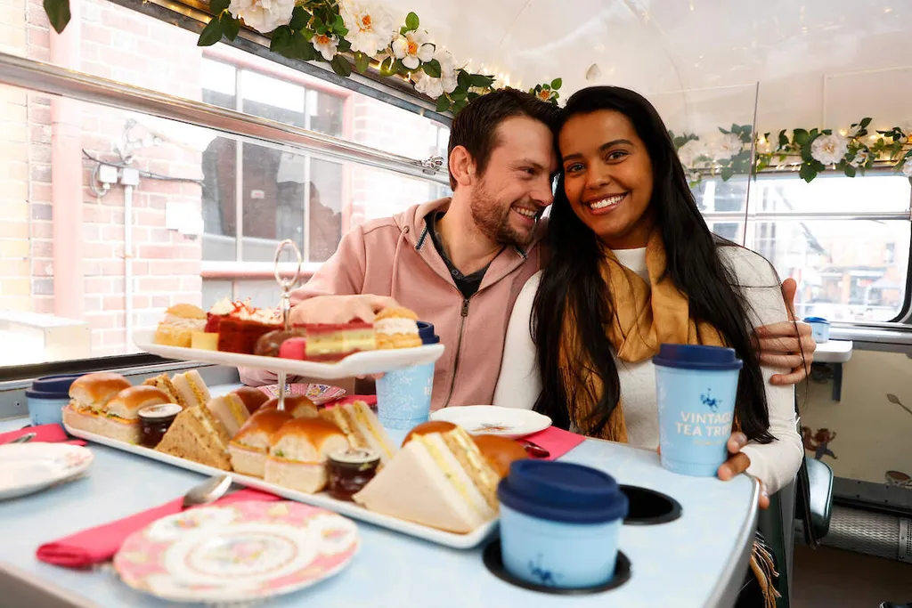 Couple enjoying afternoon tea on a vintage bus