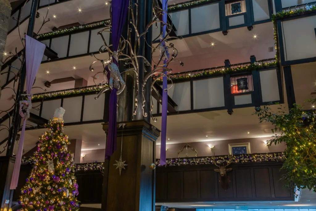 The galleried atrium hung with garlands and purple banners above a lit Christmas tree