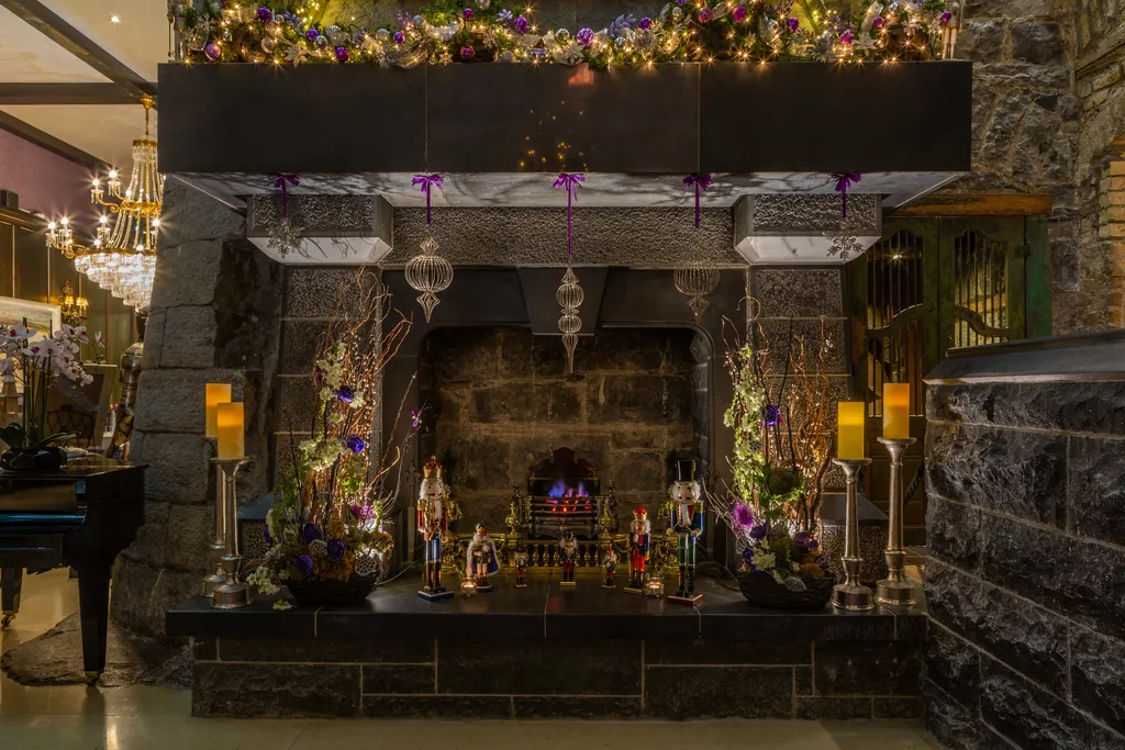 The lobby’s stone fireplace dressed with purple garlands, nutcrackers, candles and hanging ornaments