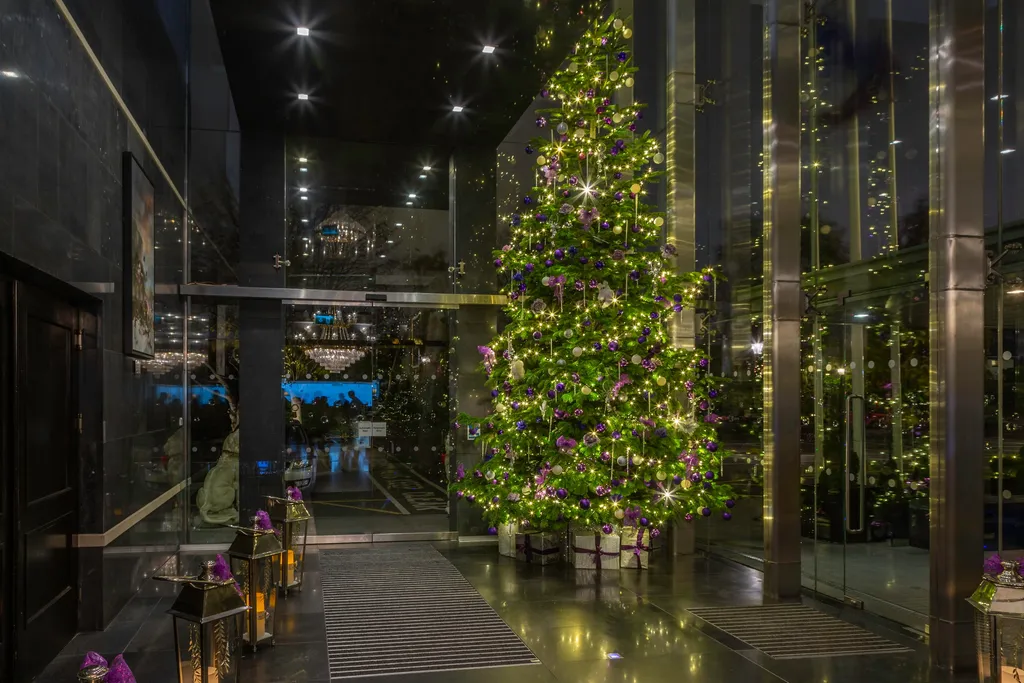 The hotel’s glass entrance vestibule with a lit Christmas tree and lanterns