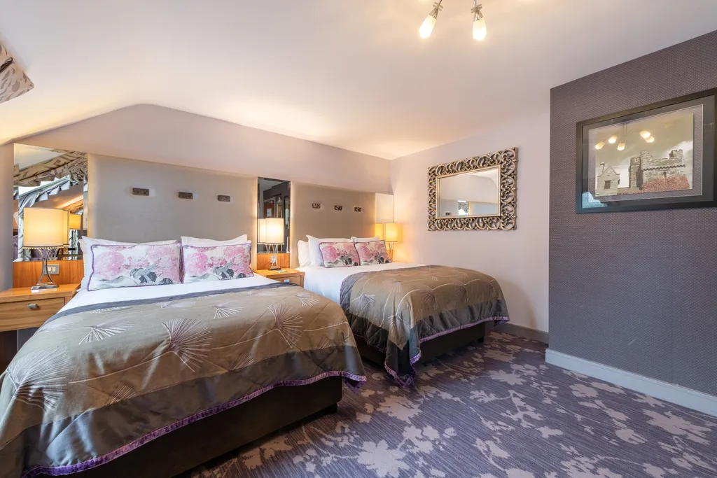 Executive Family Room with two beds, pink floral cushions and ornate framed mirrors