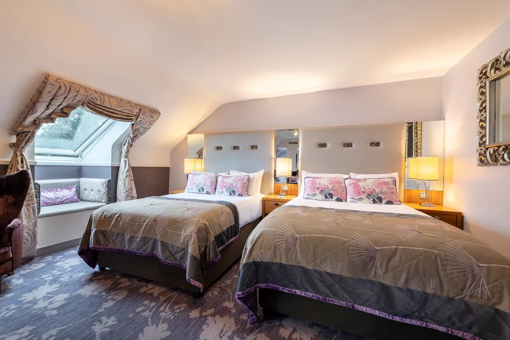 Executive Family Room in the eaves, with two beds and a curtained dormer window seat