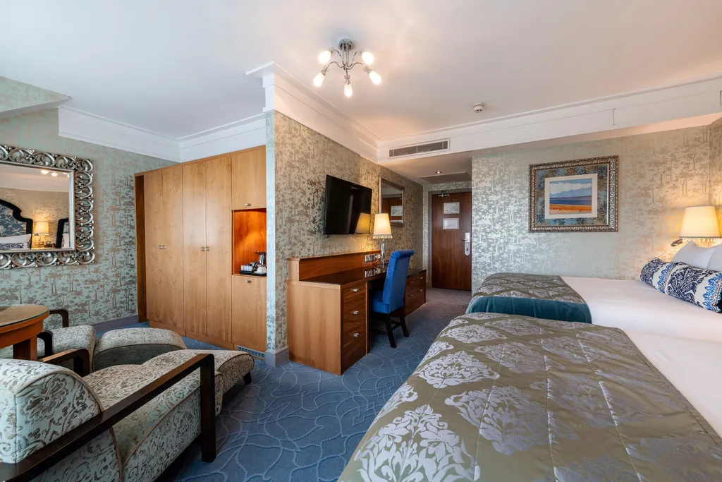 Executive Family Room with a chaise longue, wardrobe, desk and two beds