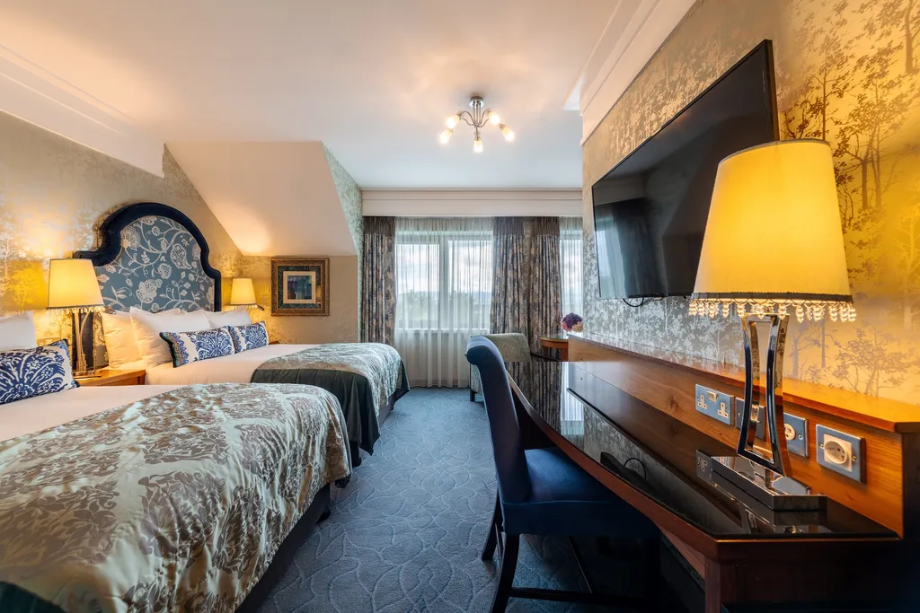 Executive Family Room with two beds, a desk with a crystal lamp and a wall-mounted TV