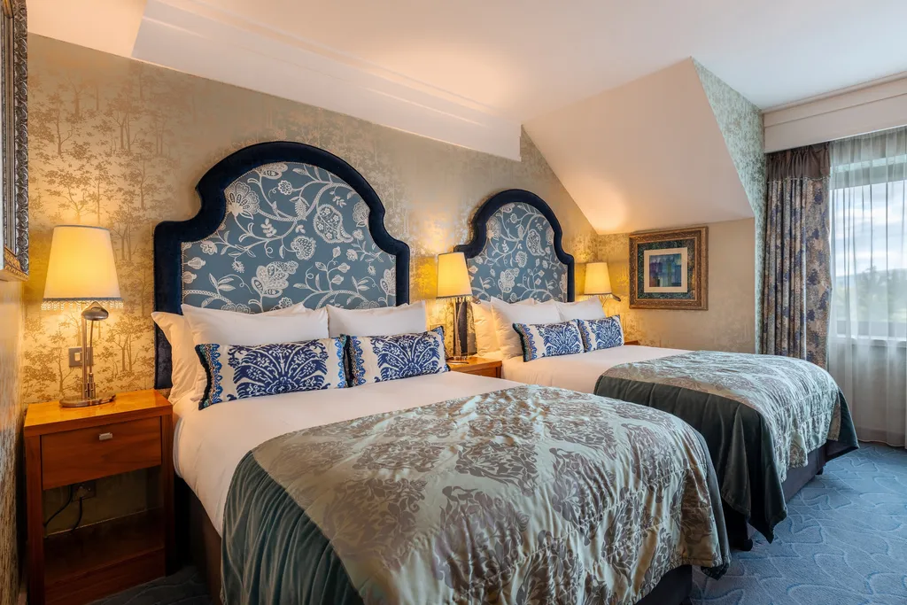 Family Room with two beds, arched blue floral headboards and damask bedspreads