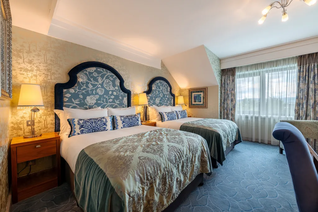 Family Room with two beds, arched blue headboards and windows with grey curtains