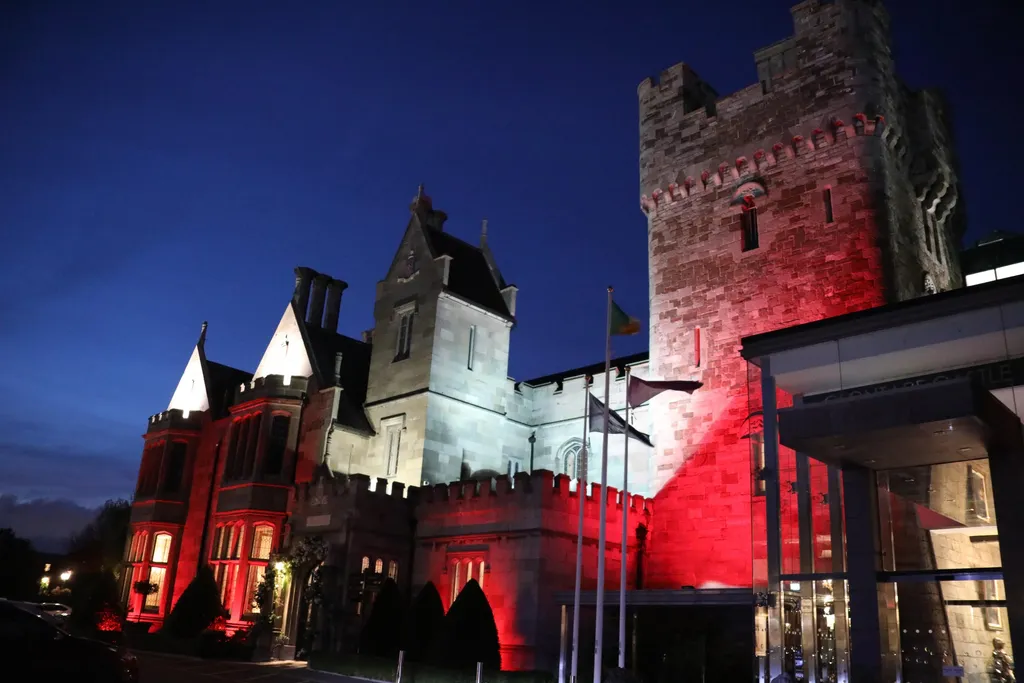 The castle tower lit red against the night sky