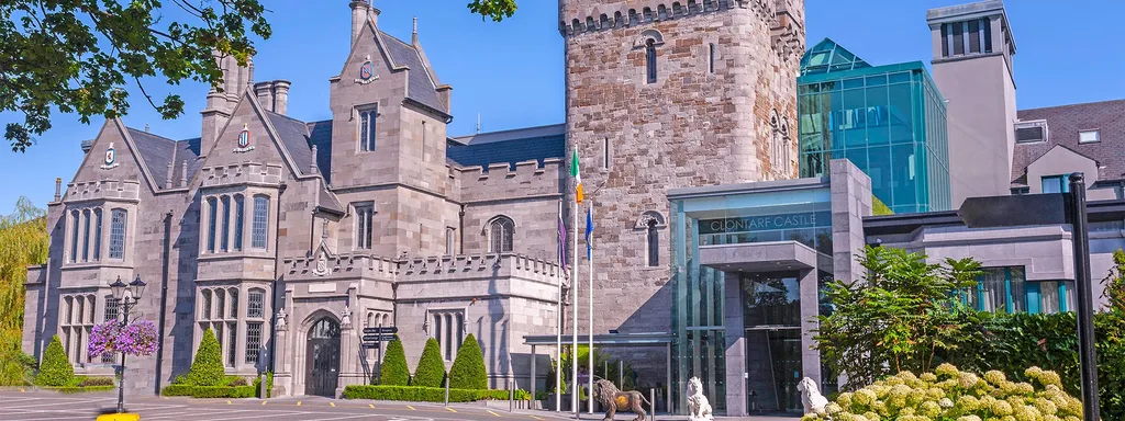 Clontarf Castle Hotel’s stone towers and glass entrance on a sunny day